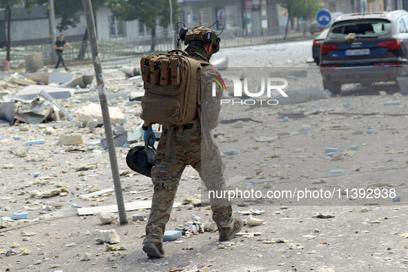 A serviceman is walking through the rubble in the street near the Lukianivska metro station during a Russian missile attack in Kyiv, Ukraine...