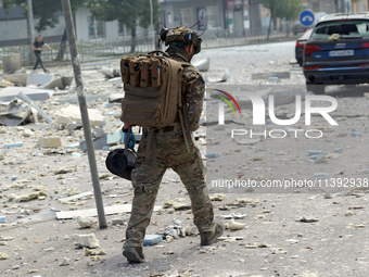 A serviceman is walking through the rubble in the street near the Lukianivska metro station during a Russian missile attack in Kyiv, Ukraine...