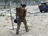 A serviceman is walking through the rubble in the street near the Lukianivska metro station during a Russian missile attack in Kyiv, Ukraine...