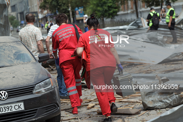 Paramedics are walking through the rubble in the street near the Lukianivska metro station during a Russian missile attack in Kyiv, Ukraine,...