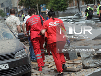 Paramedics are walking through the rubble in the street near the Lukianivska metro station during a Russian missile attack in Kyiv, Ukraine,...