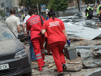 Paramedics are walking through the rubble in the street near the Lukianivska metro station during a Russian missile attack in Kyiv, Ukraine,...