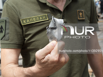 A chaplain is showing a piece of a Russian missile found near the Lukianivska metro station in Kyiv, Ukraine, on July 8, 2024. NO USE RUSSIA...