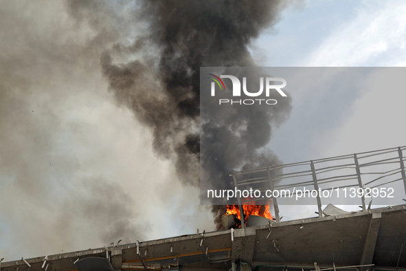 The roof of an unfinished building is catching fire near the Lukianivska metro station as a result of a Russian missile attack in Kyiv, Ukra...