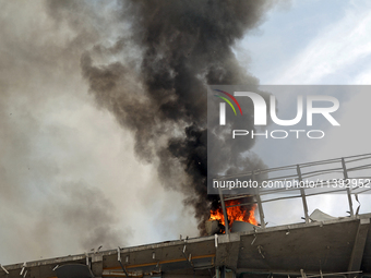 The roof of an unfinished building is catching fire near the Lukianivska metro station as a result of a Russian missile attack in Kyiv, Ukra...