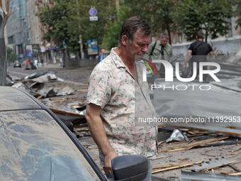 A man is standing by a car parked near the Lukianivska metro station during a Russian missile attack in Kyiv, Ukraine, on July 8, 2024. NO U...