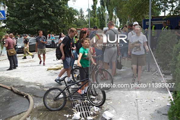 People are staying outside a building in the Solomianskyi district destroyed by a Russian missile strike in Kyiv, Ukraine, on July 8, 2024....