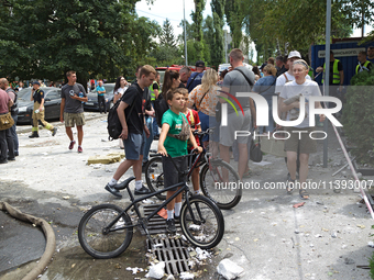 People are staying outside a building in the Solomianskyi district destroyed by a Russian missile strike in Kyiv, Ukraine, on July 8, 2024....