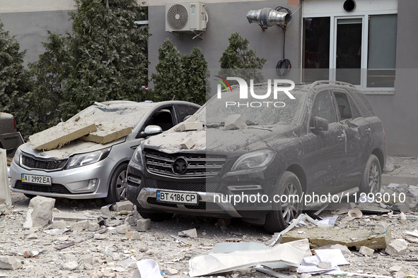 Cars are being crushed by the rubble and are parked at an office building in the Solomianskyi district damaged by a Russian missile strike i...