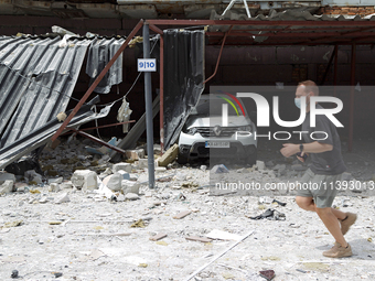 A man in a face mask is running past garages in the Solomianskyi district damaged by a Russian missile strike in Kyiv, Ukraine, on July 8, 2...