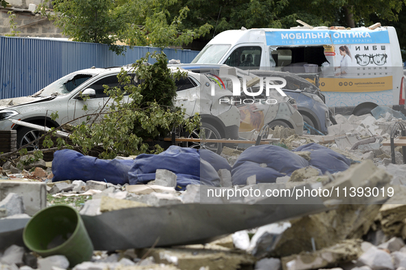 Cars are being crushed by the rubble and are parked at an office building in the Solomianskyi district damaged by a Russian missile strike i...