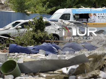 Cars are being crushed by the rubble and are parked at an office building in the Solomianskyi district damaged by a Russian missile strike i...