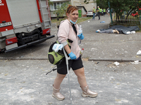 A woman is walking with a crutch in the Solomianskyi district during a response effort to a Russian missile strike in Kyiv, Ukraine, on July...