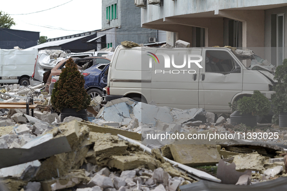 Cars are being crushed by the rubble and are parked at an office building in the Solomianskyi district damaged by a Russian missile strike i...