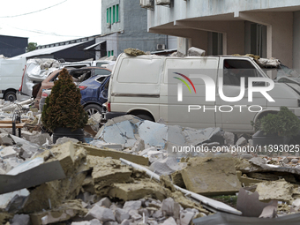 Cars are being crushed by the rubble and are parked at an office building in the Solomianskyi district damaged by a Russian missile strike i...