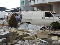 Cars are being crushed by the rubble and are parked at an office building in the Solomianskyi district damaged by a Russian missile strike i...