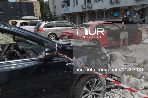 Cars are being crushed by the rubble and are parked at an office building in the Solomianskyi district damaged by a Russian missile strike i...