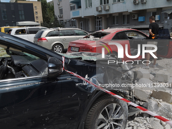 Cars are being crushed by the rubble and are parked at an office building in the Solomianskyi district damaged by a Russian missile strike i...