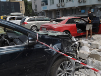 Cars are being crushed by the rubble and are parked at an office building in the Solomianskyi district damaged by a Russian missile strike i...