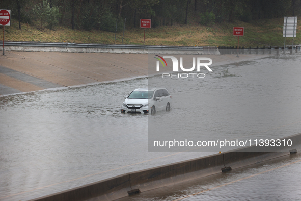 A single car is being seen abandoned on a flooded I10 at Washington St. in Houston, Texas, on July 8, 2024. 