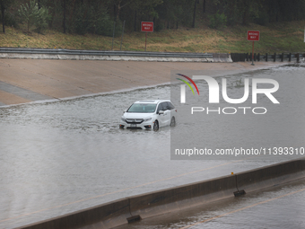 A single car is being seen abandoned on a flooded I10 at Washington St. in Houston, Texas, on July 8, 2024. (