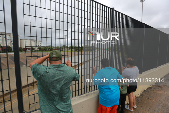 Spectators are taking pictures and videos of the flooding on I10 at Washington St. in Houston, Texas, on July 8, 2024. 