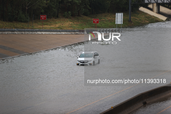 A single car is being seen abandoned on a flooded I10 at Washington St. in Houston, Texas, on July 8, 2024. 