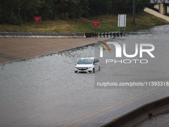 A single car is being seen abandoned on a flooded I10 at Washington St. in Houston, Texas, on July 8, 2024. (