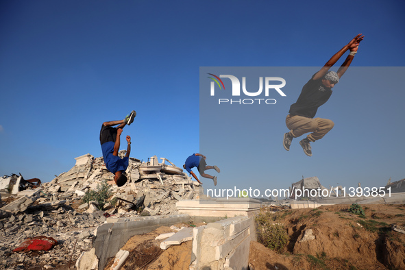 Palestinian youths are playing parkour at the ruins of a building destroyed in recent Israeli air strikes, in Zawayda, in the central Gaza S...