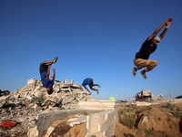 Palestinian youths are playing parkour at the ruins of a building destroyed in recent Israeli air strikes, in Zawayda, in the central Gaza S...