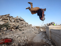 Palestinian youths are playing parkour at the ruins of a building destroyed in recent Israeli air strikes, in Zawayda, in the central Gaza S...