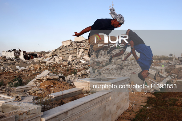 Palestinian youths are playing parkour at the ruins of a building destroyed in recent Israeli air strikes, in Zawayda, in the central Gaza S...