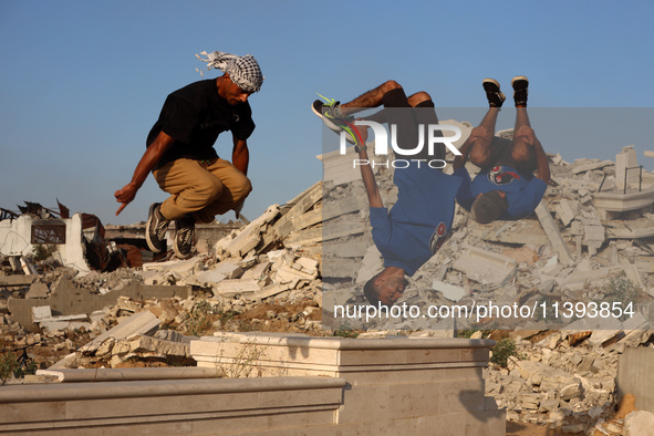 Palestinian youths are playing parkour at the ruins of a building destroyed in recent Israeli air strikes, in Zawayda, in the central Gaza S...