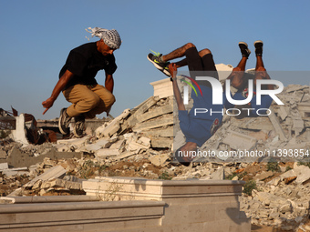 Palestinian youths are playing parkour at the ruins of a building destroyed in recent Israeli air strikes, in Zawayda, in the central Gaza S...