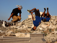 Palestinian youths are playing parkour at the ruins of a building destroyed in recent Israeli air strikes, in Zawayda, in the central Gaza S...