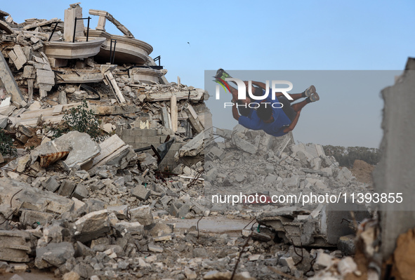 Palestinian youths are playing parkour at the ruins of a building destroyed in recent Israeli air strikes, in Zawayda, in the central Gaza S...