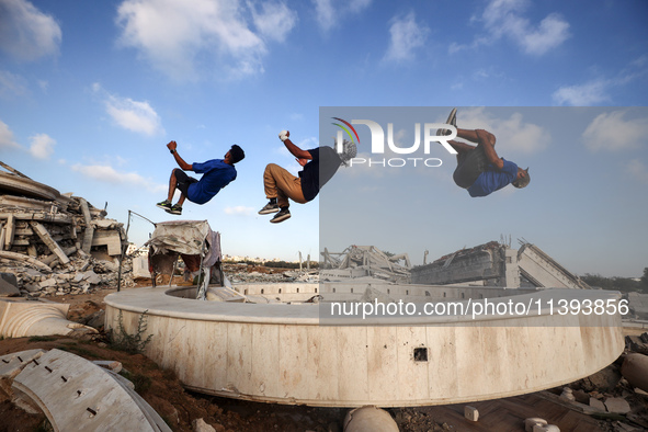 Palestinian youths are playing parkour at the ruins of a building destroyed in recent Israeli air strikes, in Zawayda, in the central Gaza S...