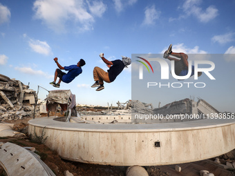 Palestinian youths are playing parkour at the ruins of a building destroyed in recent Israeli air strikes, in Zawayda, in the central Gaza S...