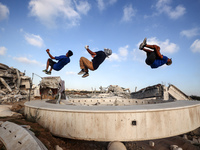 Palestinian youths are playing parkour at the ruins of a building destroyed in recent Israeli air strikes, in Zawayda, in the central Gaza S...