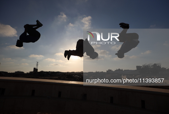 Palestinian youths are playing parkour at the ruins of a building destroyed in recent Israeli air strikes, in Zawayda, in the central Gaza S...