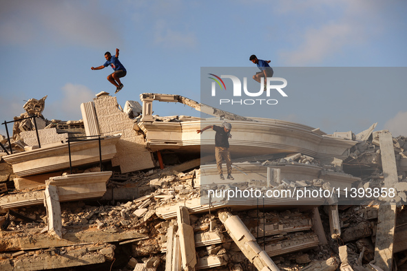 Palestinian youths are playing parkour at the ruins of a building destroyed in recent Israeli air strikes, in Zawayda, in the central Gaza S...