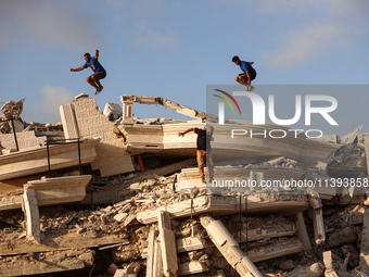 Palestinian youths are playing parkour at the ruins of a building destroyed in recent Israeli air strikes, in Zawayda, in the central Gaza S...