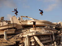 Palestinian youths are playing parkour at the ruins of a building destroyed in recent Israeli air strikes, in Zawayda, in the central Gaza S...