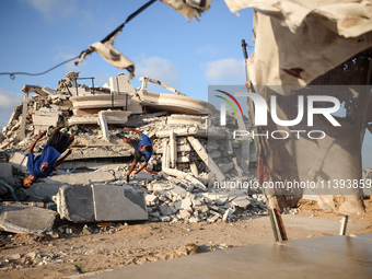 Palestinian youths are playing parkour at the ruins of a building destroyed in recent Israeli air strikes, in Zawayda, in the central Gaza S...