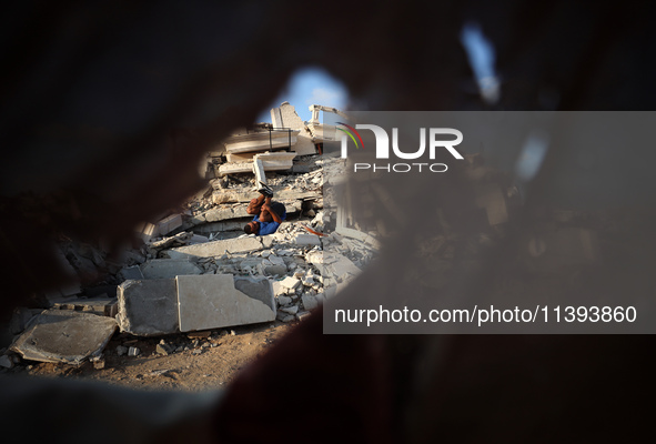 A Palestinian youth is practicing parkour at the ruins of a building destroyed in recent Israeli air strikes, in Zawayda in the central Gaza...