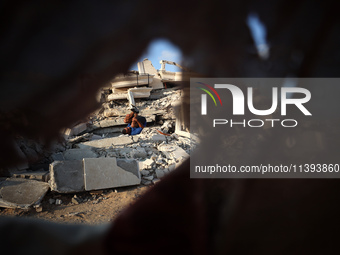 A Palestinian youth is practicing parkour at the ruins of a building destroyed in recent Israeli air strikes, in Zawayda in the central Gaza...