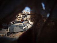 A Palestinian youth is practicing parkour at the ruins of a building destroyed in recent Israeli air strikes, in Zawayda in the central Gaza...