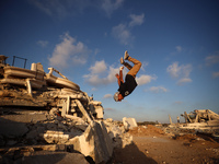 A Palestinian youth is practicing parkour at the ruins of a building destroyed in recent Israeli air strikes, in Zawayda in the central Gaza...