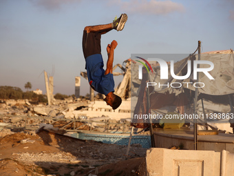 A Palestinian youth is practicing parkour at the ruins of a building destroyed in recent Israeli air strikes, in Zawayda in the central Gaza...