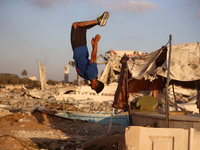 A Palestinian youth is practicing parkour at the ruins of a building destroyed in recent Israeli air strikes, in Zawayda in the central Gaza...